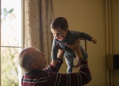 grandpa holding baby in multigenerational living arrangement