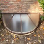 egress window well cover surrounded by fallen leaves window well maintenance egress solutions