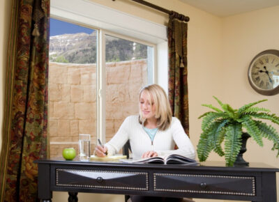 types of egress windows woman seated at desk by egress window indoors
