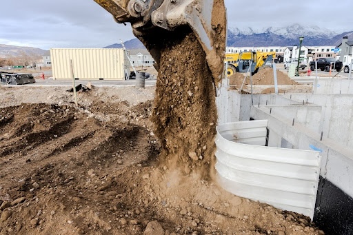 excavator digging soil to install an egress window well how to support a collapsing window well egress solutions south jersey